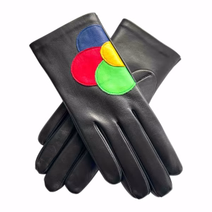 A pair of women's black Italian aniline leather gloves displayed on a white background. When the hands are placed side-by-side, the stitched leather appliques form a large, stylized flower in earthy tones of terracotta, beige, and brown.